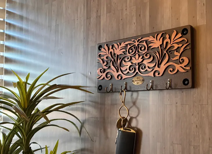 レーザーカッターで制作したアンティーク調の木製キーフック。精密な植物モチーフの透かし彫りと、メタルフックを組み合わせた壁掛け収納。