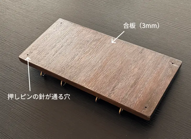 キーフックの背面。3mmの合板で仕上げられ、四隅には壁に固定するための「押しピンの針が通る穴」が設計されている様子。