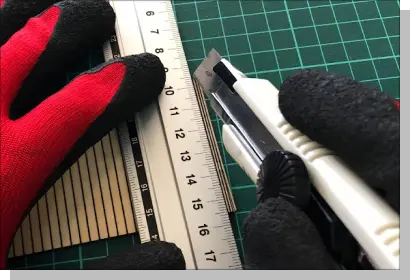 円形のウォールシェルフの側面の余分な部分をカッターでカットしているシーンの写真